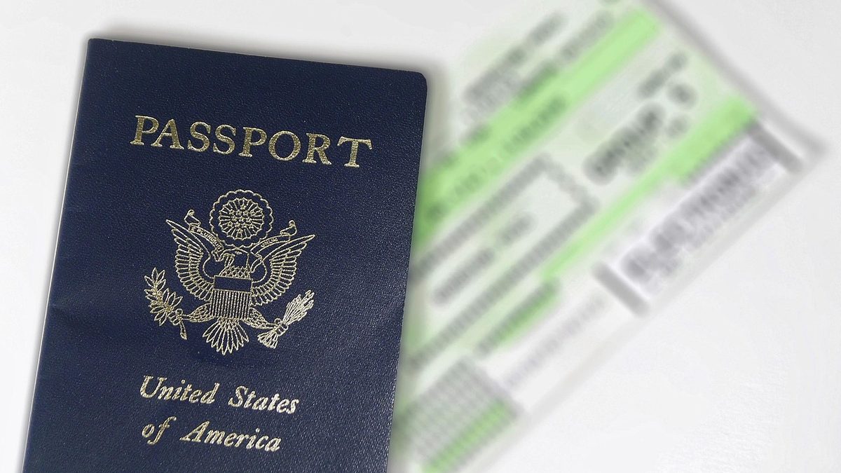 Reisepass und Flugtickets liegen nebeneinander auf einer hellen Fläche