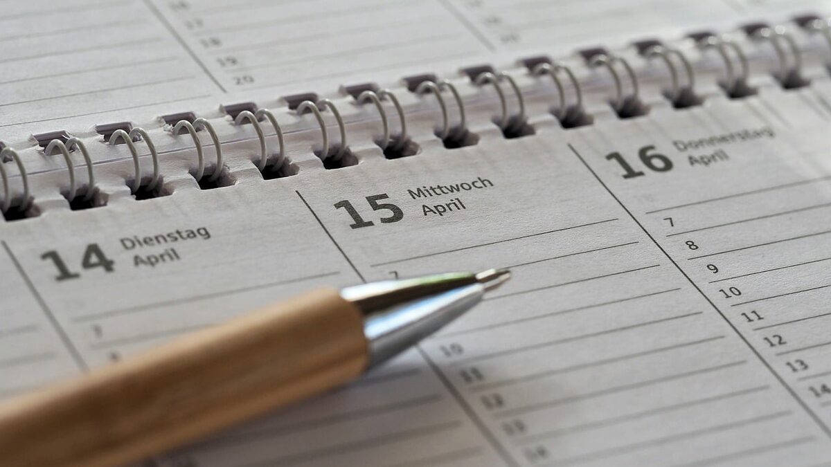 Aufgeschlagener Terminkalender mit den Tagen 14. bis 16. April, quer darauf liegt ein Kugelschreiber