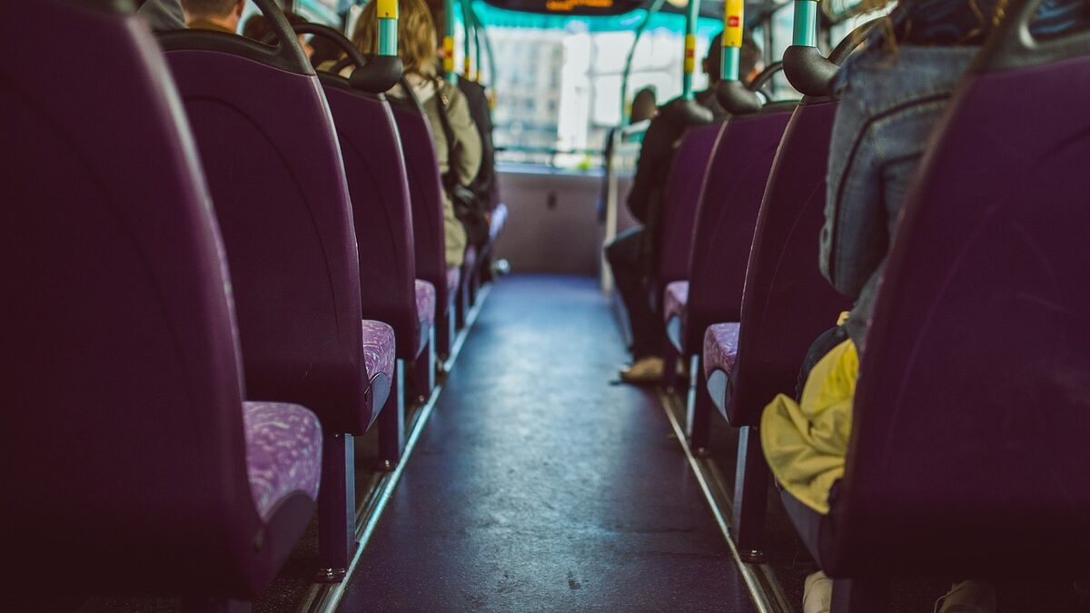 Blick durch den Mittelgang eines Busses über besetzte Sitzreihen hinweg nach vorn zur Windschutzscheibe