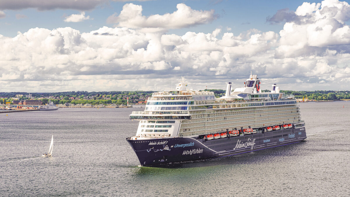Das Kreuzfahrtschiff Mein Schiff 7 in der Kieler Förde unter Wolkenhimmel
